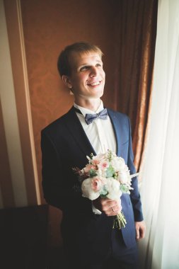 Güzel adam, damat poz veriyor ve düğüne hazırlanıyor.