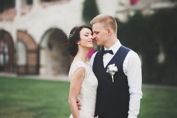 Lovely happy wedding couple, bride with long white dress posing in beautiful city — Stock Photo, Image