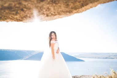 Arka plan denizin üzerinde poz güzel genç gelin