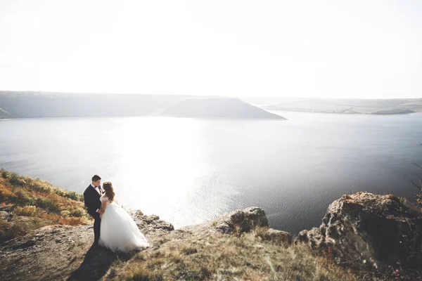 Κομψό κομψό ευτυχισμένο ζευγάρι γάμου, νύφη, πανέμορφο γαμπρό στο φόντο της θάλασσας και του ουρανού — Φωτογραφία Αρχείου