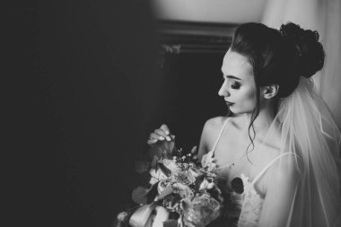 Beyaz elbiseli lüks gelin düğün törenine hazırlanırken poz veriyor.