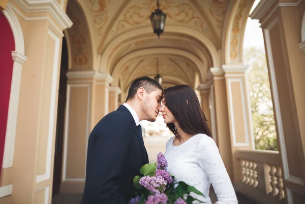 Casal bonito, noiva e noivo posando perto de grande coluna branca — Fotografia de Stock