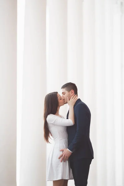 Casal bonito, noiva e noivo posando perto de grande coluna branca — Fotografia de Stock