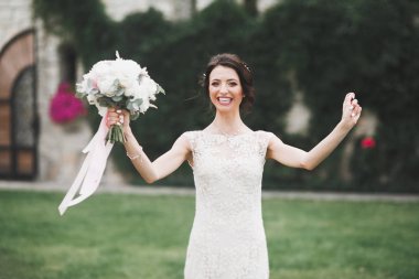 Parkta poz veren zarif beyaz elbiseli güzel gelin.