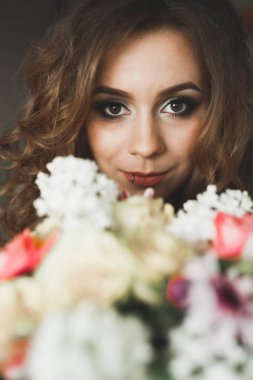 Beyaz elbiseli lüks gelin düğün törenine hazırlanırken poz veriyor.