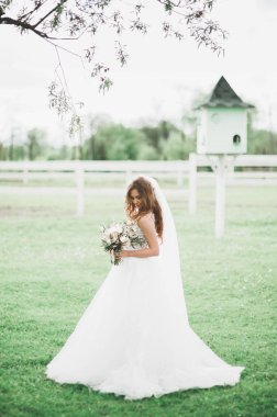 Gelinlik içinde dışarıda poz veren güzel gelin.