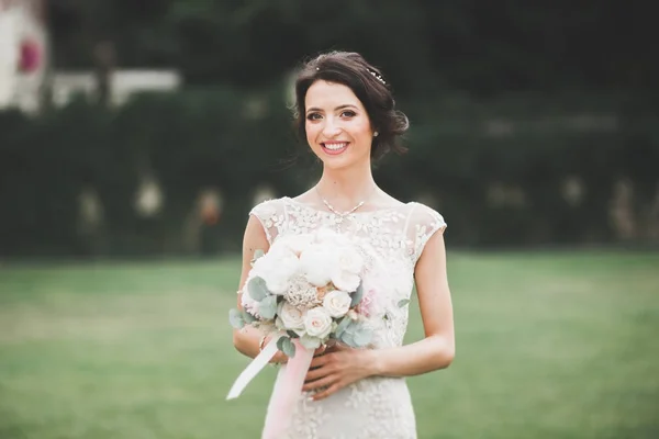 Красива розкішна молода наречена у весільній сукні позує в парку — стокове фото