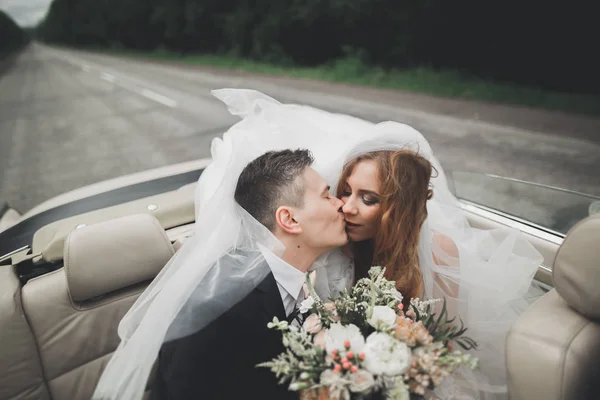 Snyggt bröllopspar, brud, brudgum kyssas och kramas på retrobil — Stockfoto