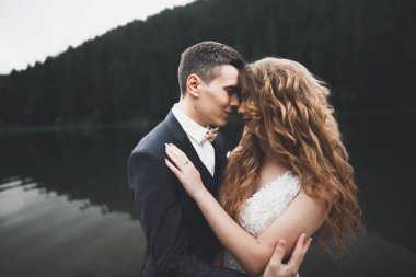 Mükemmel bir çift gelin ve damat düğün günlerinde poz verip öpüşürler.