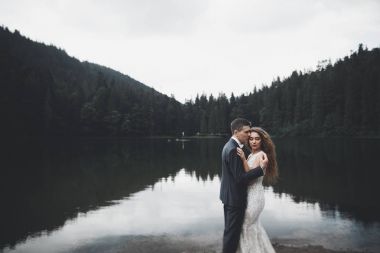 Harika bir gelin damada poz veriyor ve harika manzaralı dağlarda lüks bir tören yapıyor.