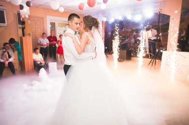 Güzel beyaz bir çift yeni evlendiler ve ilk danslarını ediyorlar.