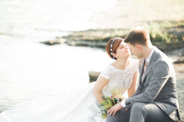 Gelin ve damat güzel düğün buket tutarak. Nehir kenarında poz