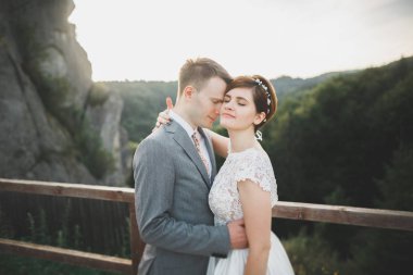 Öpüşen düğün çifti güzel manzarada kalıyor.