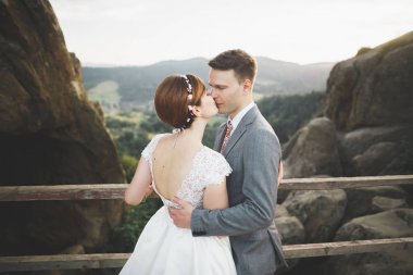 Öpüşen düğün çifti güzel manzarada kalıyor.