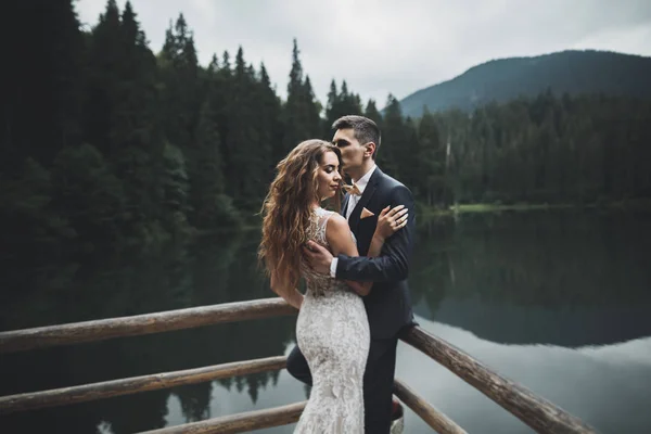 Prachtige prachtige bruid poseren om bruidegom en het hebben van plezier, luxe ceremonie in de bergen met een prachtig uitzicht, ruimte voor tekst, bruiloft paar — Stockfoto