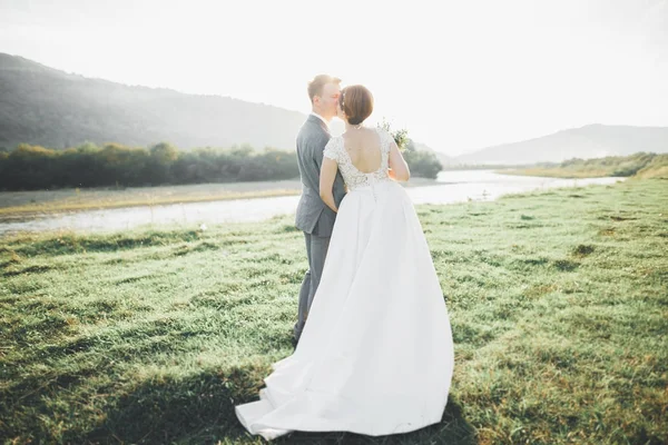 Великолепная невеста и стильный жених, гуляющий по солнечному пейзажу, свадебная пара, роскошные торжественные горы с изумительным видом, пространство для текста — стоковое фото
