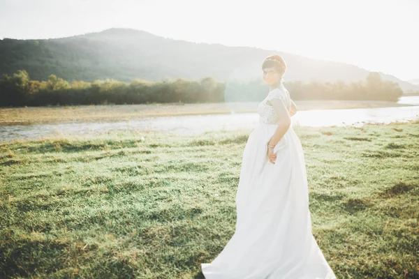 Mulher de beleza, noiva com vestido branco perfeito posando nas montanhas de fundo de rocha — Fotografia de Stock