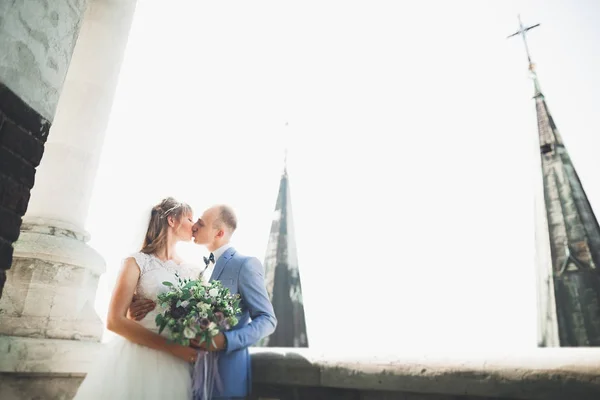 Elegante hermosa pareja de boda besándose y abrazándose en el fondo vista panorámica del casco antiguo — Foto de Stock