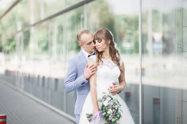 素敵な幸せな結婚式のカップル、モダンな建物に近いポーズ長い白いドレスと花嫁 — ストック写真