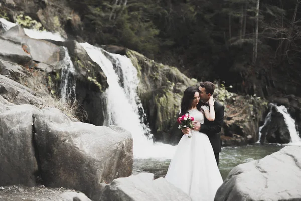 Couple de mariage amoureux embrasser et étreindre près des rochers sur un beau paysage — Photo