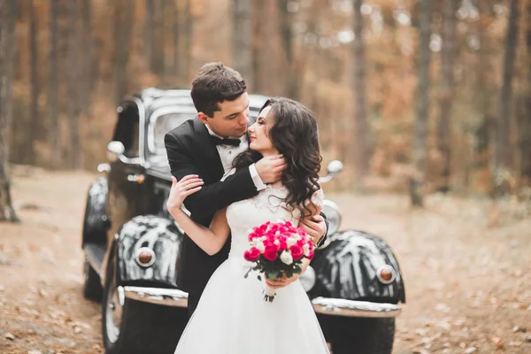 Красива весільна пара позує біля прекрасної ретро-автомобіля — стокове фото