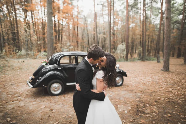 Pareja recién casada en el lujoso coche retro el día de su boda — Foto de Stock