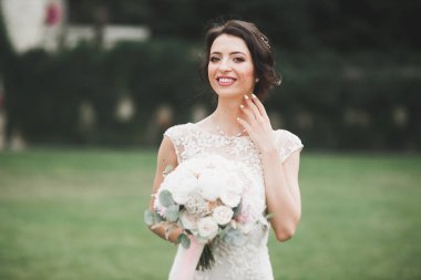 Parkta poz veren gelinlikli güzel, lüks bir gelin.