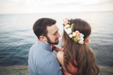 Mavi Denizi çevresinde büyük bir taş üzerinde oturan Düğün çifti