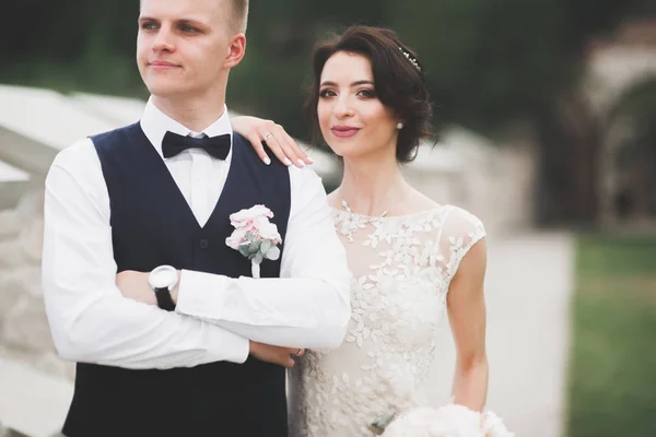 Schönes glückliches Hochzeitspaar, Braut mit langem weißen Kleid posiert in schöner Stadt — Stockfoto