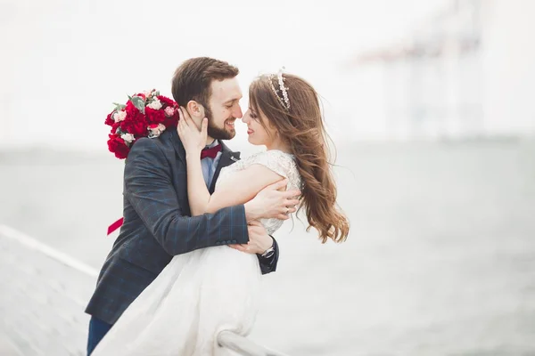 Casamento casal apenas andando na praia ao pôr do sol . — Fotografia de Stock