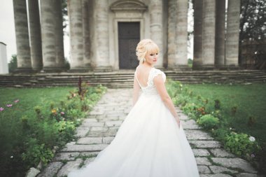 Parkta poz veren gelinlikli güzel, lüks bir gelin.