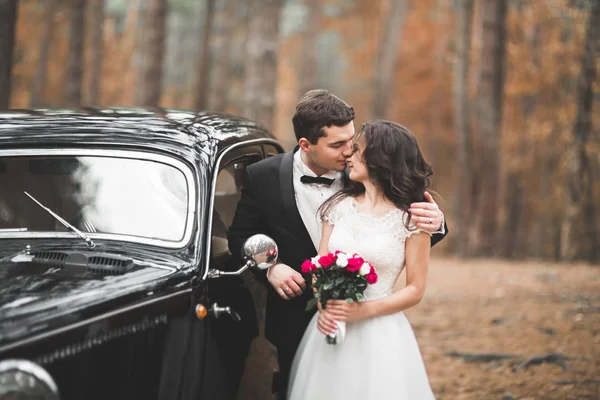 Apenas casal no carro retro de luxo em seu dia do casamento — Fotografia de Stock