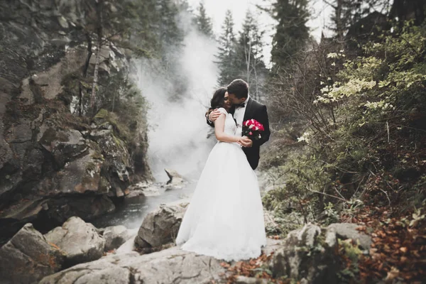 Couple de mariage, marié et mariée câlin, en plein air près de la rivière — Photo