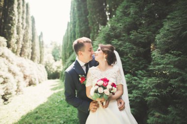 Yeni evli çift el ele tutuşurken parkta koşup zıplıyorlar.