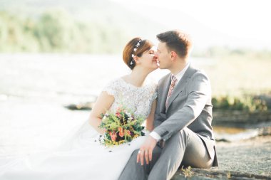 Yakışıklı romantik damat ve güzel gelin Nehri manzaralı dağlarında yakınında poz