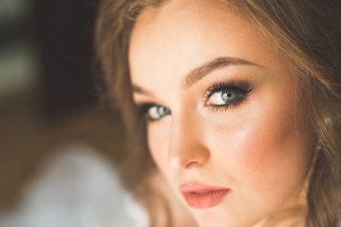 Cüppeli muhteşem gelin bir odada düğün töreni için poz veriyor ve hazırlanıyor.