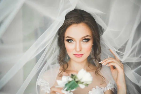 Красива наречена в модній весільній сукні з пір'ям з розкішним захоплюючим макіяжем і зачіскою, студія в приміщенні фотосесії — стокове фото