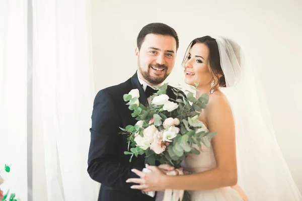 Sesión de fotos de boda de la pareja de recién casados en un hermoso hotel posando cerca de la ventana — Foto de Stock