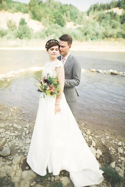 优雅温柔时尚新郎和新娘用石头河附近。婚礼热恋中的情侣 — 图库照片