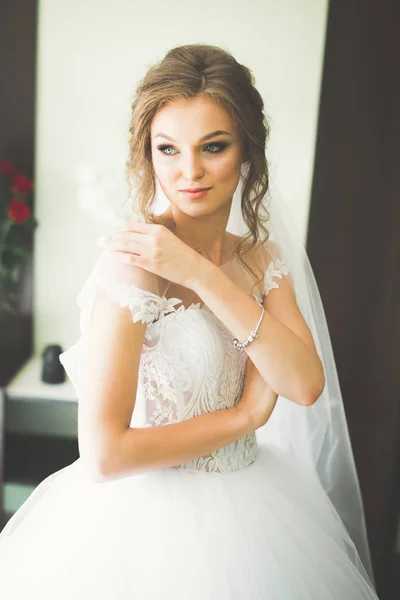 Gorgeous bride in robe posing and preparing for the wedding ceremony face in a room — Stock Photo, Image