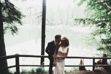 Yeni evli çift el ele tutuşurken parkta koşup zıplıyorlar.