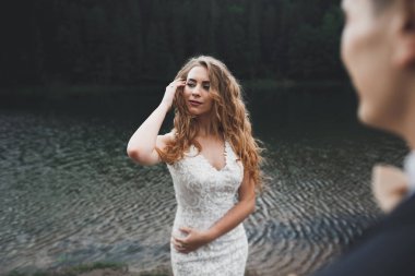 Harika bir gelin damada poz veriyor ve harika manzaralı dağlarda lüks bir tören yapıyor.