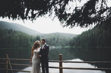 Harika bir gelin damada poz veriyor ve harika manzaralı dağlarda lüks bir tören yapıyor.