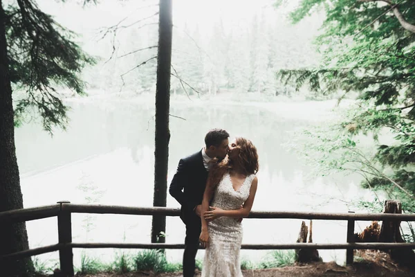 Pareja recién casada corriendo y saltando en el parque mientras se toma de la mano — Foto de Stock