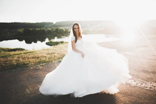 Feliz bela noiva jovem lá fora em um prado de verão no pôr do sol — Fotografia de Stock