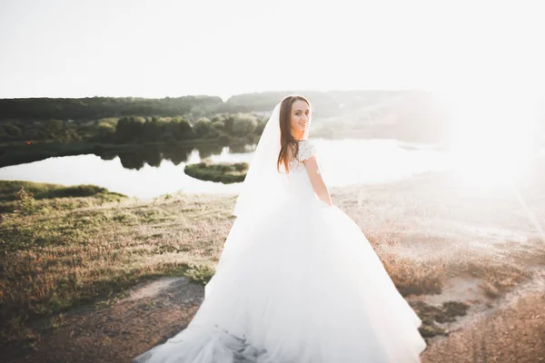 Красивая невеста позирует в свадебном платье на открытом воздухе — стоковое фото