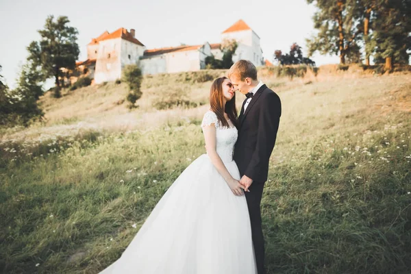 Mooi sprookje pasgetrouwd koppel knuffelen in de buurt van oud middeleeuws kasteel — Stockfoto