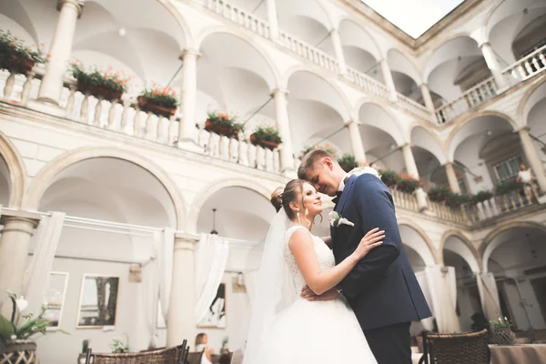 Bella coppia di nozze felice, sposa con abito lungo bianco in posa nella bella città — Foto Stock