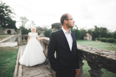 Güzel, romantik bir düğün. Yeni evliler. Eski kalenin yakınlarında sarılıyorlar.