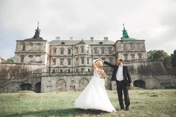 Όμορφη ρομαντική γάμο ζευγάρι των νεόνυμφων αγκαλιάζει κοντά στο παλιό κάστρο — Φωτογραφία Αρχείου